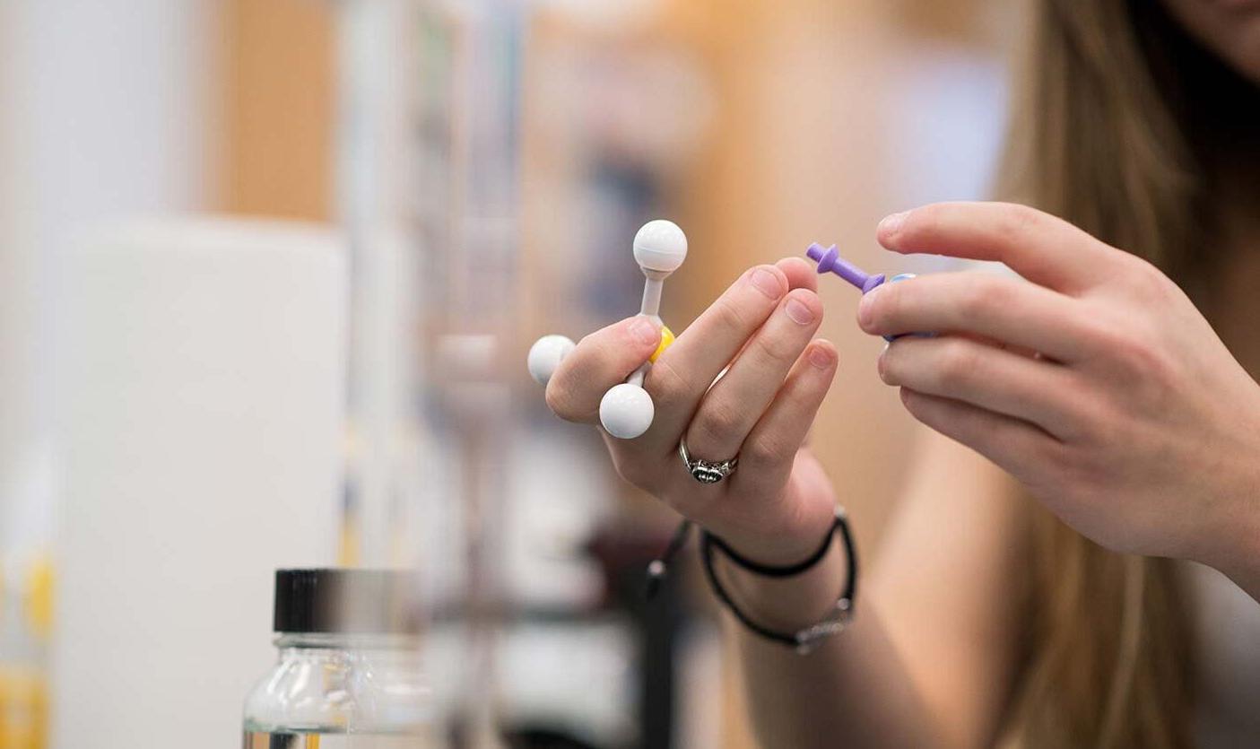 Closeup of student holding chemistry model in a lab